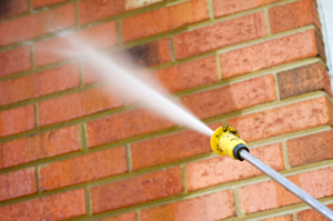 brick wall undergoing pressure washing